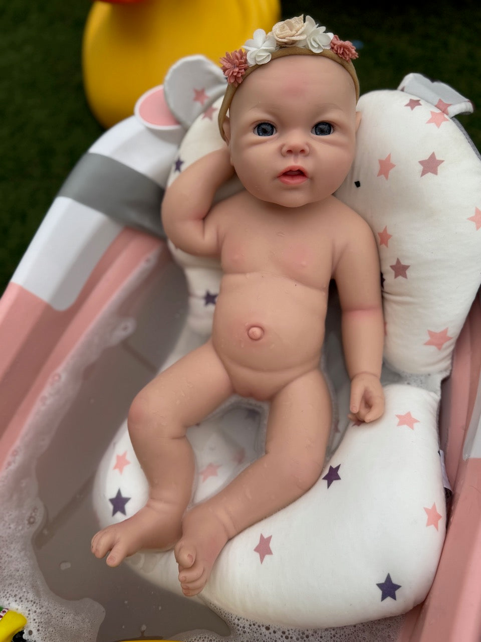 Bebé reborn de silicona en una bañera pequeña