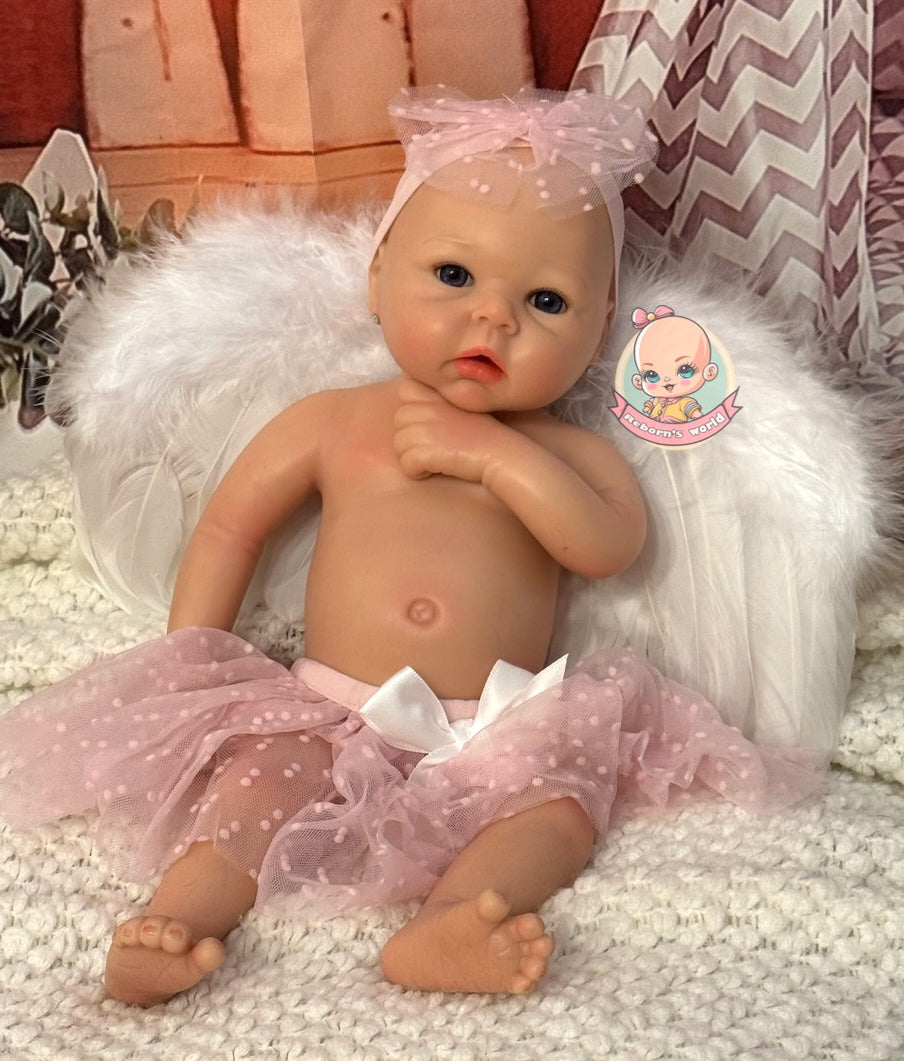 muneca reborn maya tumbada y mano en barbilla